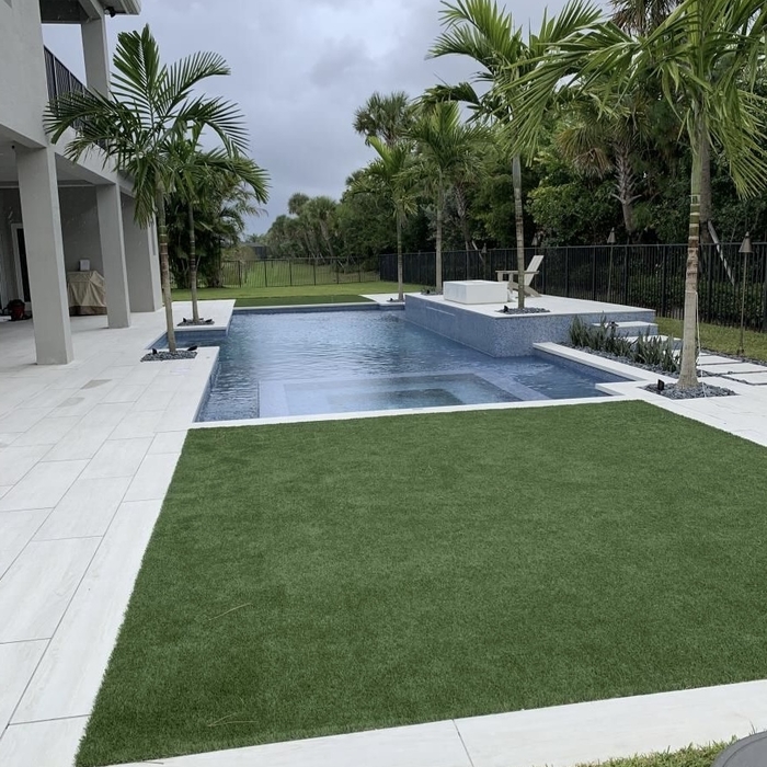 Artificial grass, palm trees, fence, and pavers!